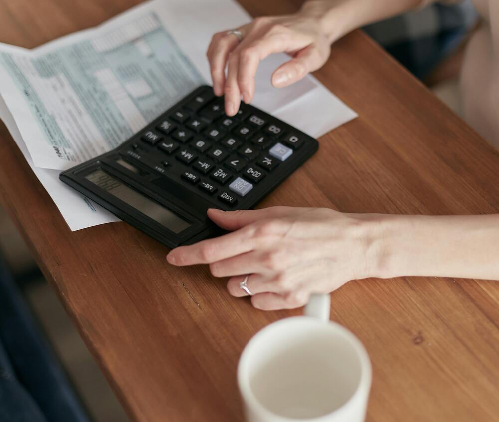 Calculadora na mesa, para ajudar a diminuir as dívidas.